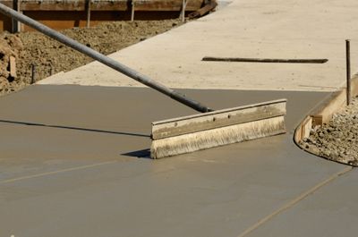 Concrete contractor screeding fresh poured concrete at a business in San Antonio TX